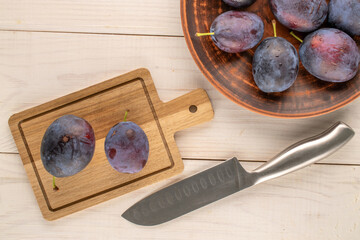 Sweet plums on a wooden table, close-up, top view.