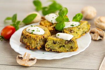 Homemade baked potato and mushroom cakes served with cream