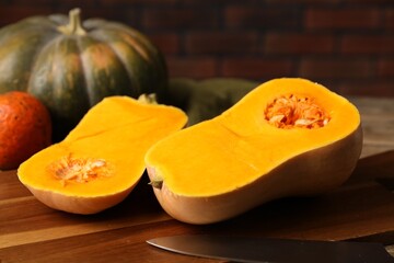 Fresh pumpkins and knife on table, closeup