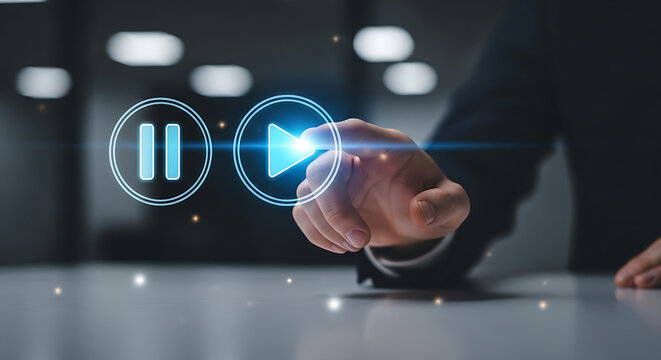 A hand pressing a blue glowing play button next to a pause button on a light surface table