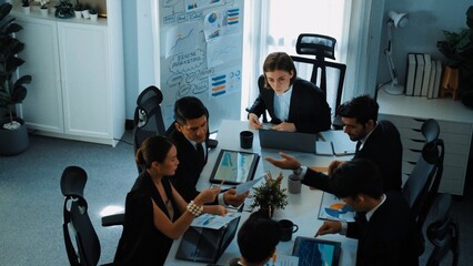 Top view of investor handed financial document to manager while explain marketing idea at meeting table. Diverse people looking at growing graph while listen business team discussion. Directorate.