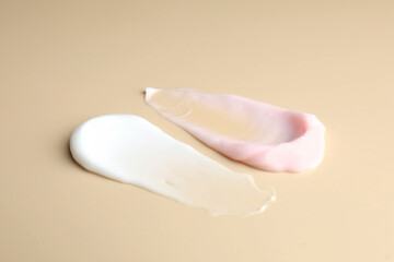 Samples of different cosmetic products on beige background, closeup