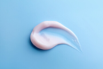 Sample of moisturizing cream on light blue background, top view