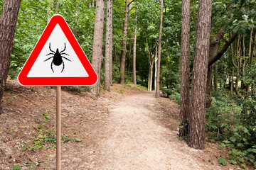 Warning sign marking habitat of ticks in forest