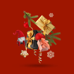 Christmas or New Year celebration. Gift boxes, cookie and festive decor flying on red background