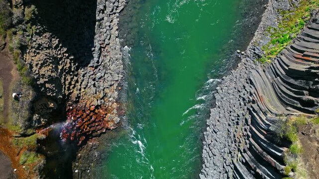 Drone view of glacial river in Stu&eth;lagil Canyon, East Iceland. The geometric basalt walls rise steeply from the turquoise water below.