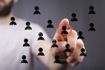 Hand selecting a person icon from a crowd, ideal for recruitment, HR, and talent acquisition.