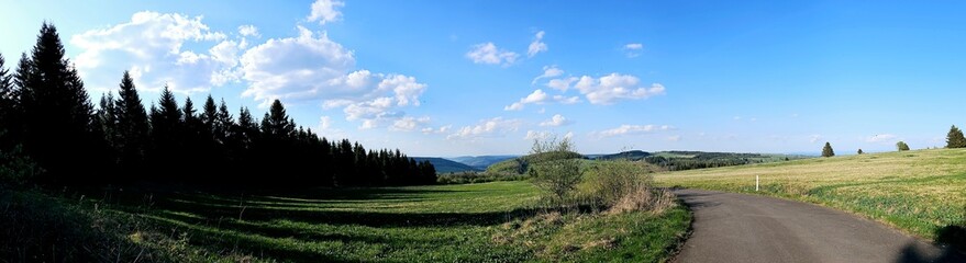 panorama of beautiful countryside of Rhoen, Hesse, Germany. sunny afternoon. wonderful springtime landscape in mountains. grassy field and rolling hills. rural scenery.
