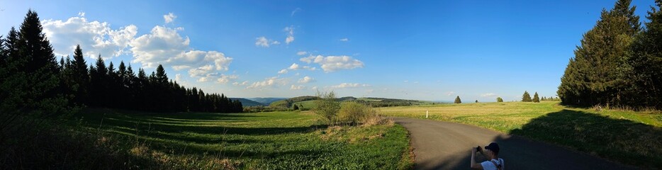 panorama of beautiful countryside of Rhoen, Hesse, Germany. sunny afternoon. wonderful springtime landscape in mountains. grassy field and rolling hills. rural scenery.