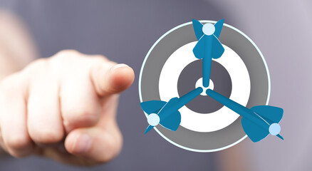 Hand pointing at a dartboard with three darts hitting the center. The concept of aiming, goals and...