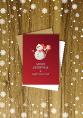 A wooden vertical surface decorated with Christmas decorations, a holiday card lies on the table, creating a warm festive atmosphere