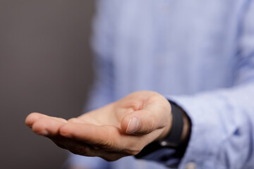 Fototapeta premium A close up shot of a man's hand, offering or receiving something. The open palm suggests giving, acceptance, or emptiness, perfect for design us