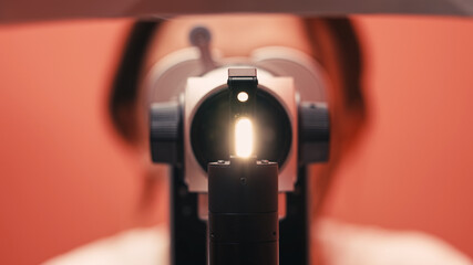 Ophthalmology examination equipment focused on light source, showcasing precision instruments and a patient in a clinical setting, emphasizing vision care and eye health