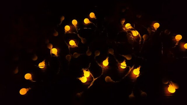 Twinkling lights of garlands illuminate wooden backdrop, embodying charming holiday vibes for joyful memories during Christmas and New Year festivities