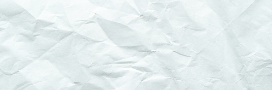 Crumpled white paper texture with wrinkles and creases in abstract background design.