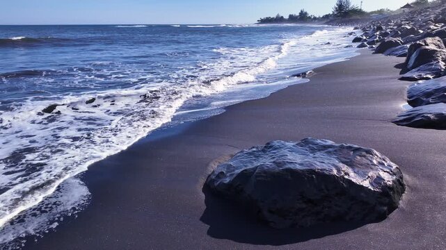Unique volcanic rock formations dotting Bali, Indonesia coastline, where ocean waves crash rhythmically, creating perfect backdrop for nature enthusiasts and travelers