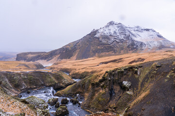 Icelandic mountain river landscape with snow and hikers