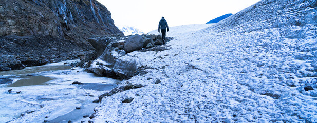 Person walking along glacier exploring nature and adventure