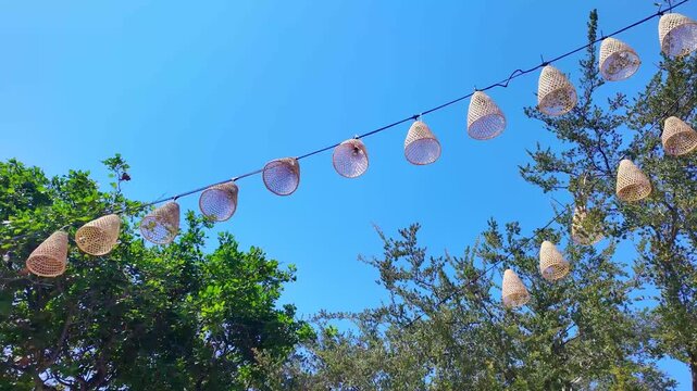 Handwoven lanterns swaying in wind, creating an enchanting atmosphere. Ideal for cozy, decorative and outdoor ambiance themes, slow motion