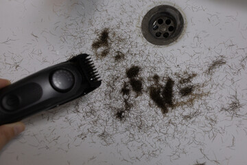 Man trimming beard and beard clippings in sink