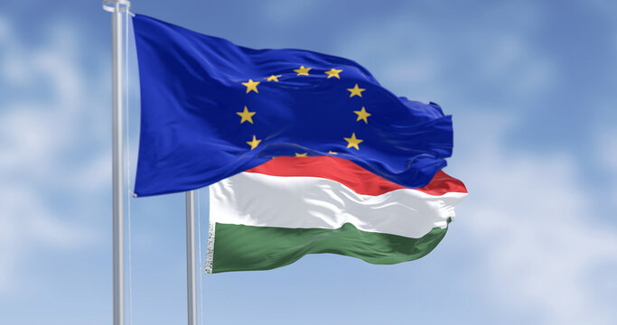 Flags of Hungary and the European Union fluttering together on a clear day