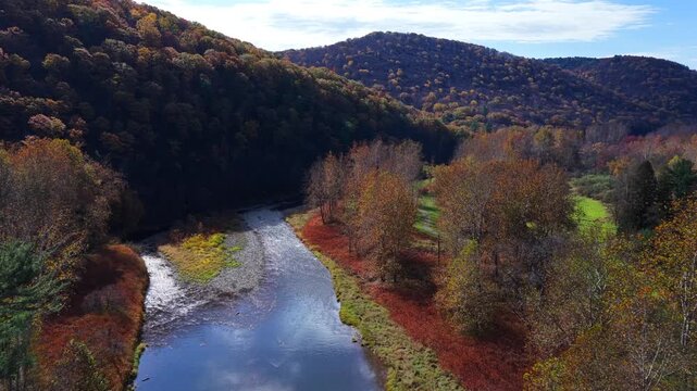Mountains in Autumn Fall colors with peaceful creek winding through countryside in morning light in Pennsylvania, Pine Creek near Pennsylvania Grand Canyon at Blackwell, PA