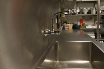 Stainless steel sink and workspace in professional kitchen