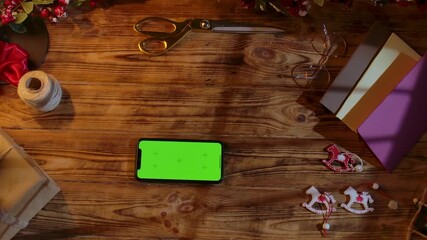 Top view of a Christmas gift wrapping scene with ribbons, scissors, paint, and homemade decorations on a rustic wooden table. Festive background for DIY holiday preparations with space for text. - Powered by Adobe