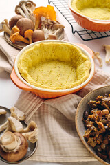 Quiche with chanterelle mushrooms, oyster mushrooms, button mushrooms, and cheese in two serving dishes