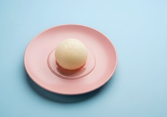 Rasgulla on a pink plate against blue background, a popular indian dessert made from milk solids and sugar syrup