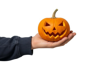 A realistic human hand holding a small carved pumpkin, visible wrist, cinematic shadow, isolated on plain green background, photorealistic