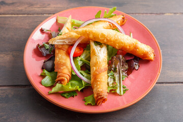 Börek turc servi dans une assiette colorée sur table en bois – présentation moderne. Variété de pâtisserie salée. 
