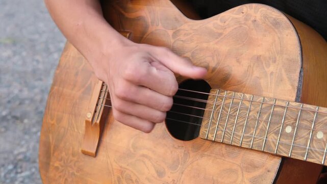 male hands playing guitar close up