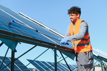 Technician cleaning solar panels in a solar farm