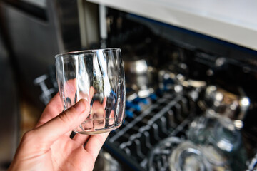 An open dishwasher with clean dishes in the kitchen.