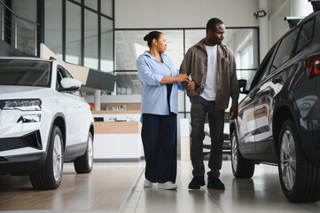Couple choosing new car in dealership showroom