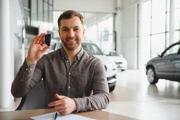Happy customer showing new car key in dealership showroom