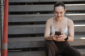 Young woman enjoying smartphone on stairs