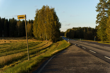 Rural bus stop along a quiet countryside road.