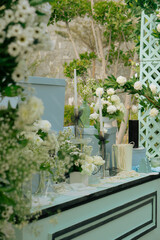 Elegant Outdoor Wedding Centerpiece Display Featuring White Roses, Candles, Pearls, and Pastel Blue Boxes