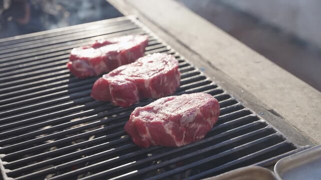 Steak being grilled on fire outdoors