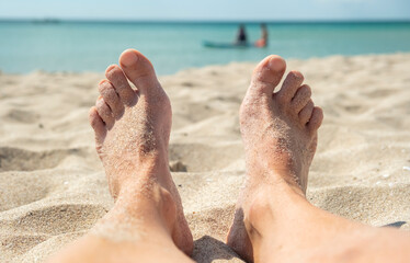 Relaxing at the beach with sandy toes and calm waters on a sunny day