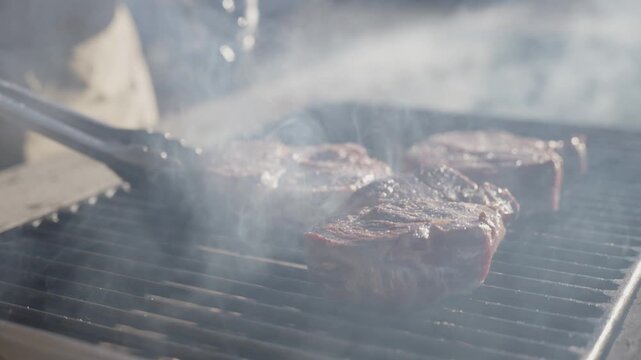 Steak being grilled on fire outdoors