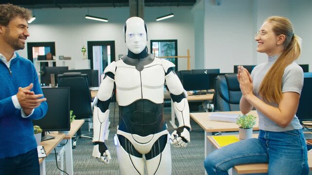 Humanoid robot taking first steps while engineering team clapping proudly. Researchers smiling and celebrating success of robotics project. Innovative experiment happening in technology workspace.