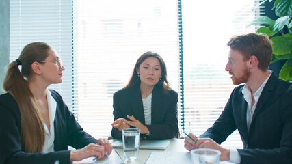 Confident woman gesturing while presenting fresh ideas during business meeting. Team listening carefully and taking notes. Creative brainstorming session. Dealing with issues together.