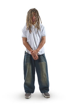 Young man with dreadlocks, hands in pockets, standing on a white background