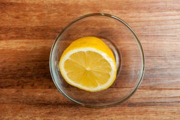 Half a lemon in a glass bowl light right side