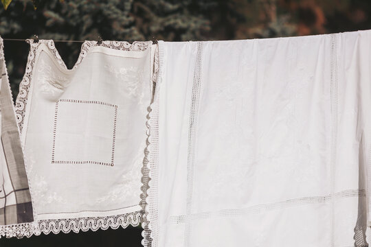 Bright afternoon sunlight kisses white linens hanging on a clothesline, creating a serene scene of domestic life in a peaceful outdoor setting