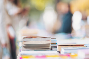 Books resting on a colorful market table inviting readers to discover stories on a sunny afternoon in a vibrant outdoor setting