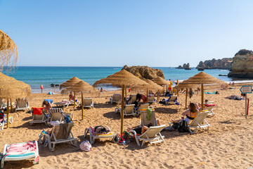 Camilo Beach  (Praia do Camilo) people were sunbathing on the beach and swimming in the ocean....